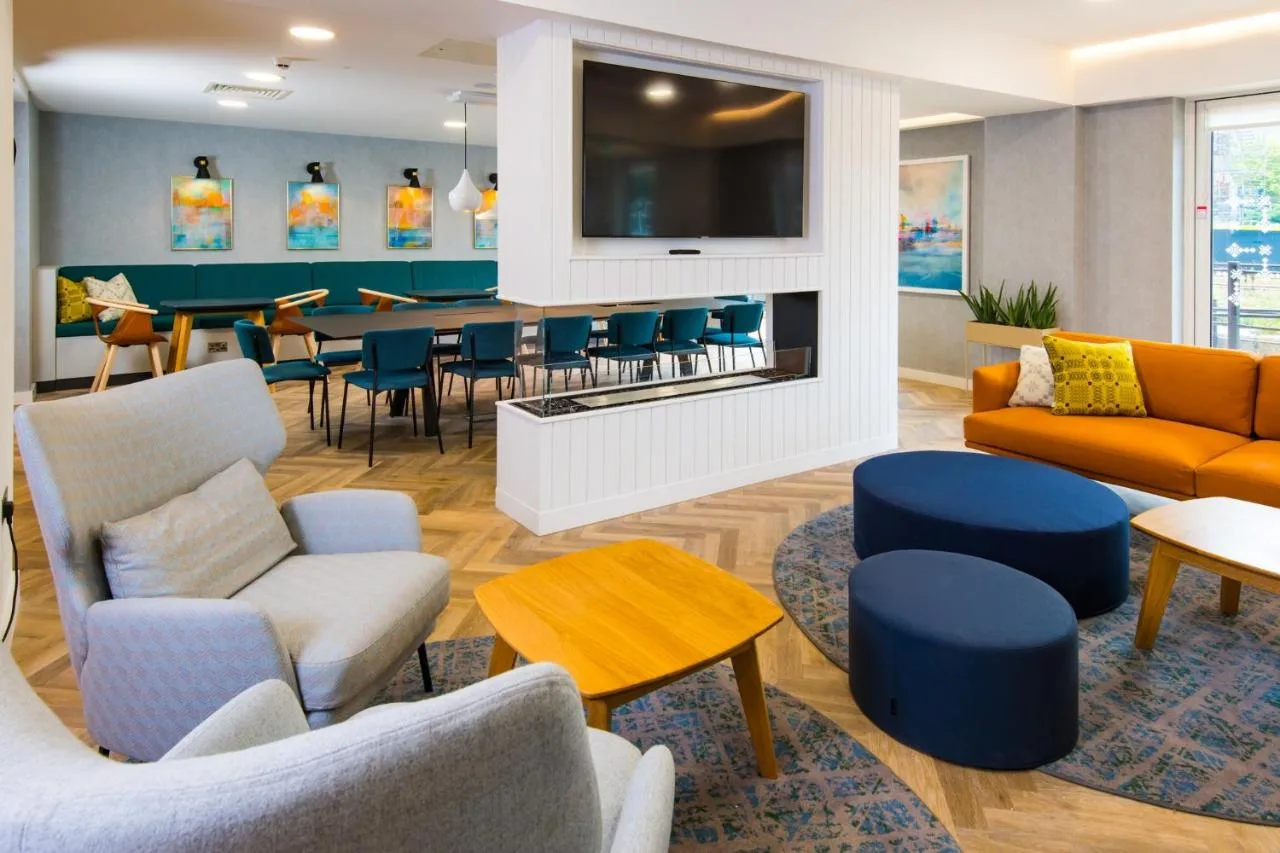 a waiting room with couches and chairs and a table at Staybridge Suites - Cardiff by IHG in Cardiff