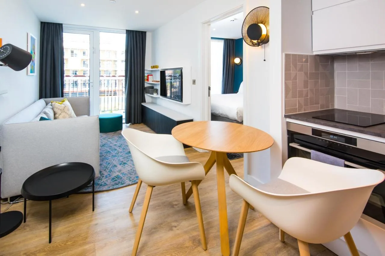 a kitchen and living room with a table and chairs at Staybridge Suites - Cardiff by IHG in Cardiff